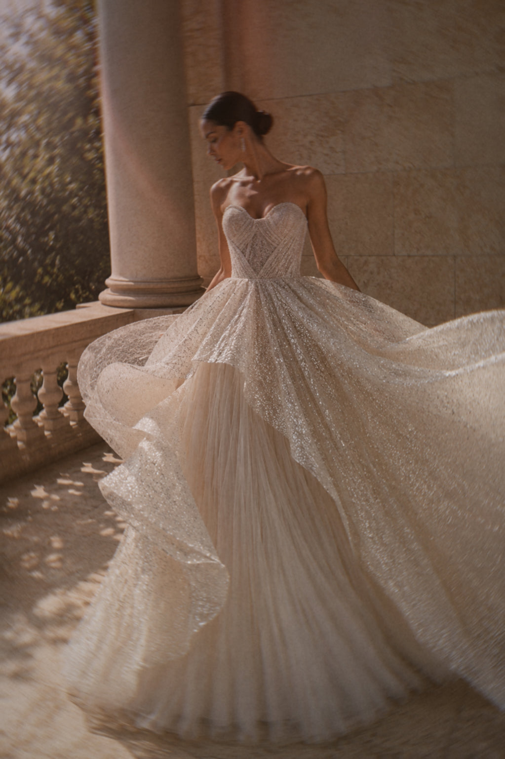 A bride twirls in a glitter tulle princess wedding dress at golden hour