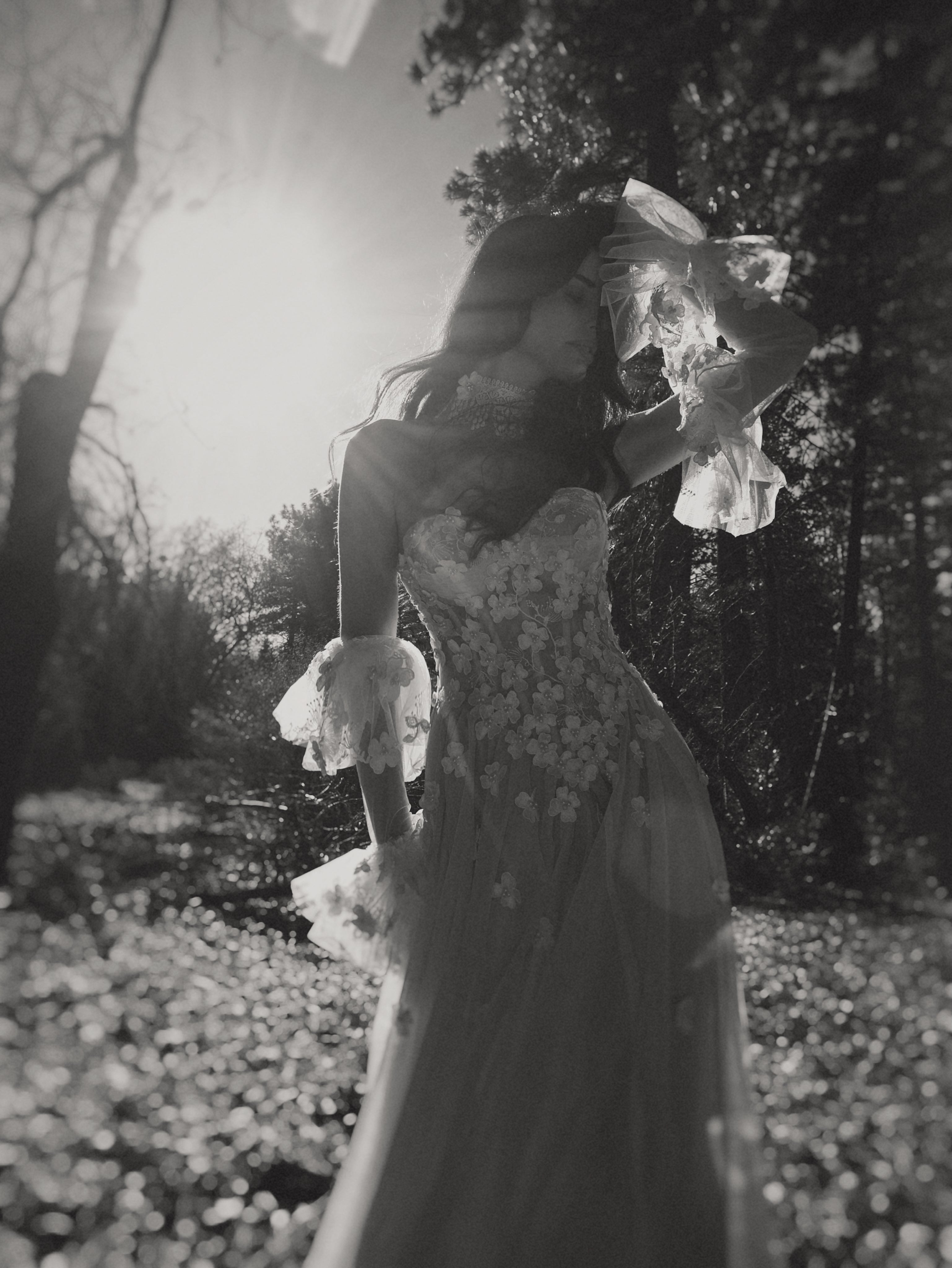 Valen bohemian wedding dress with 3D floral lace, flowing blush tulle skirt, floral bridal veil, and ethereal woodland bridal inspiration