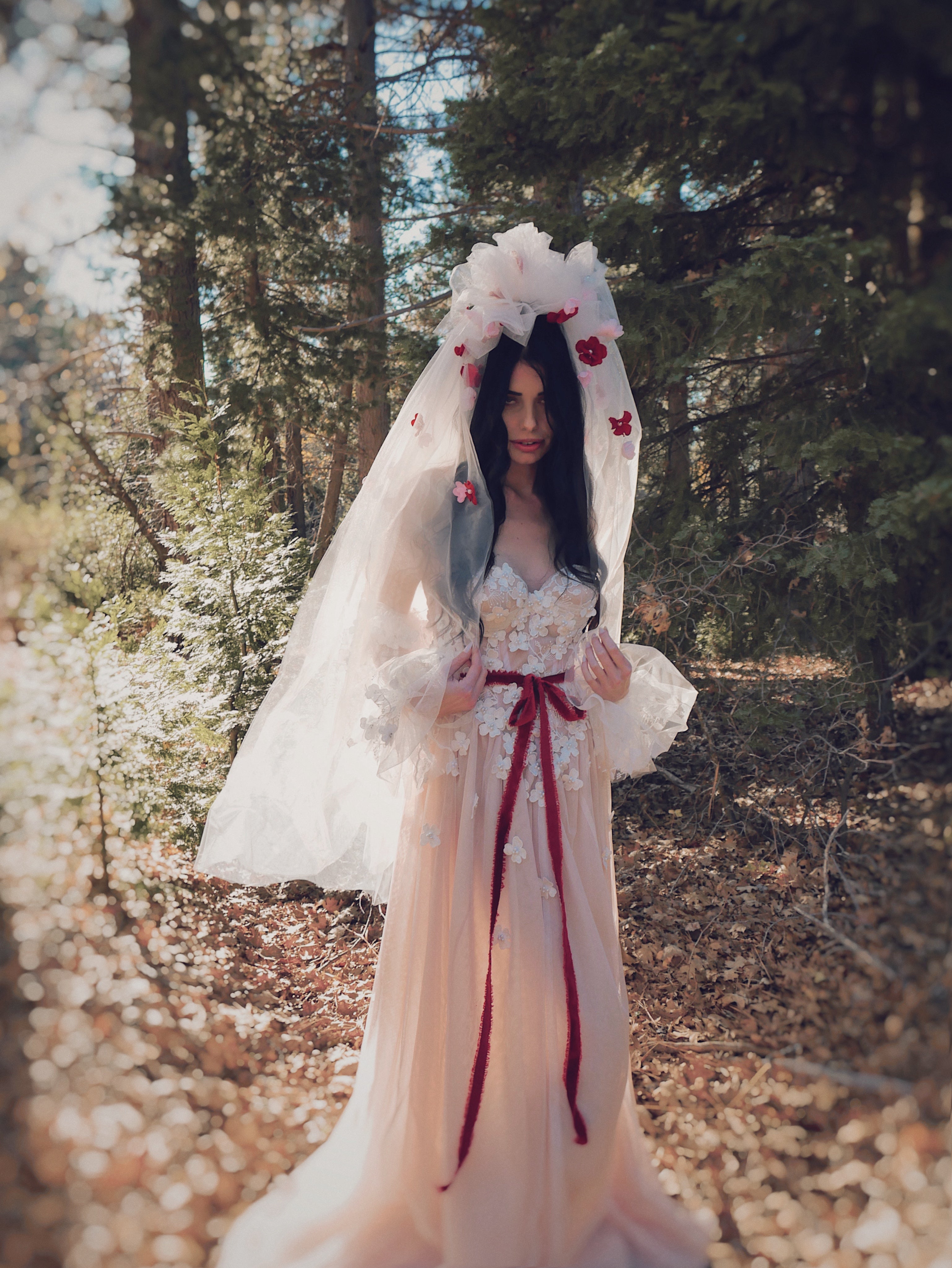 Valen bohemian wedding dress with 3D floral lace, flowing blush tulle skirt, floral bridal veil, and ethereal woodland bridal inspiration