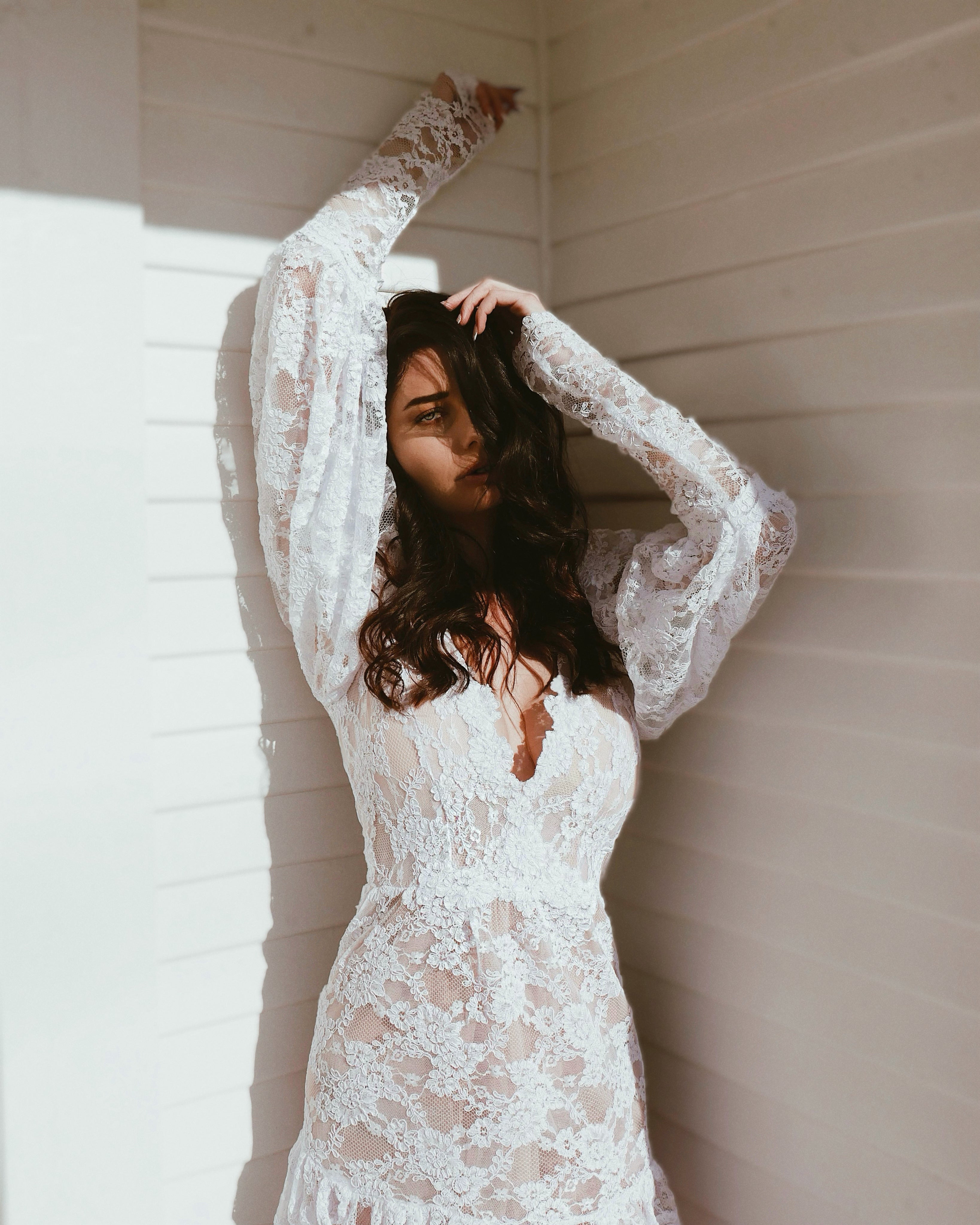 Front - A model wears a deep V neckline wedding dress with long sleeves by Lauren Elaine.