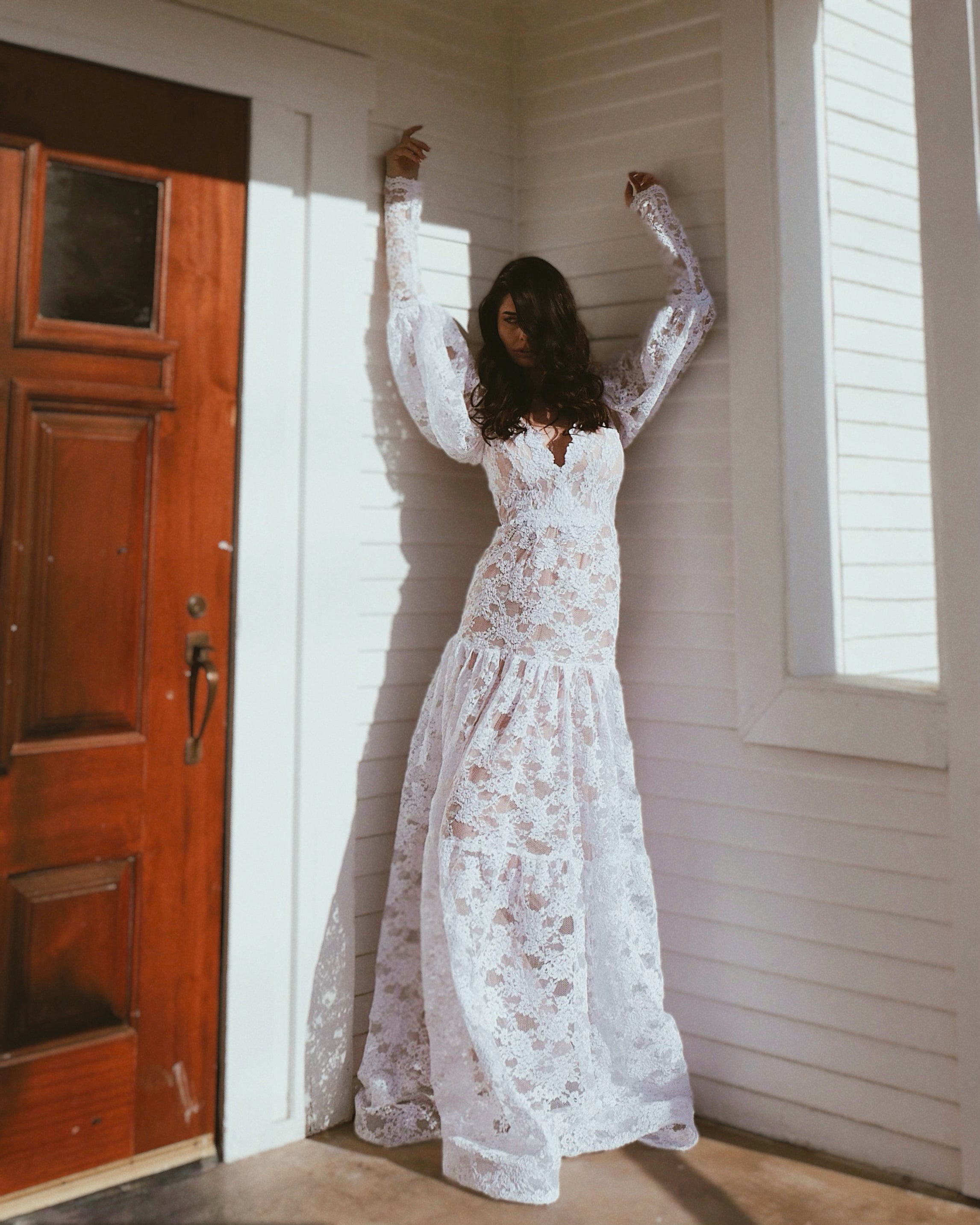 Front - a model poses in the "Meadow" vintage lace wedding gown by Lauren Elaine Bridal.