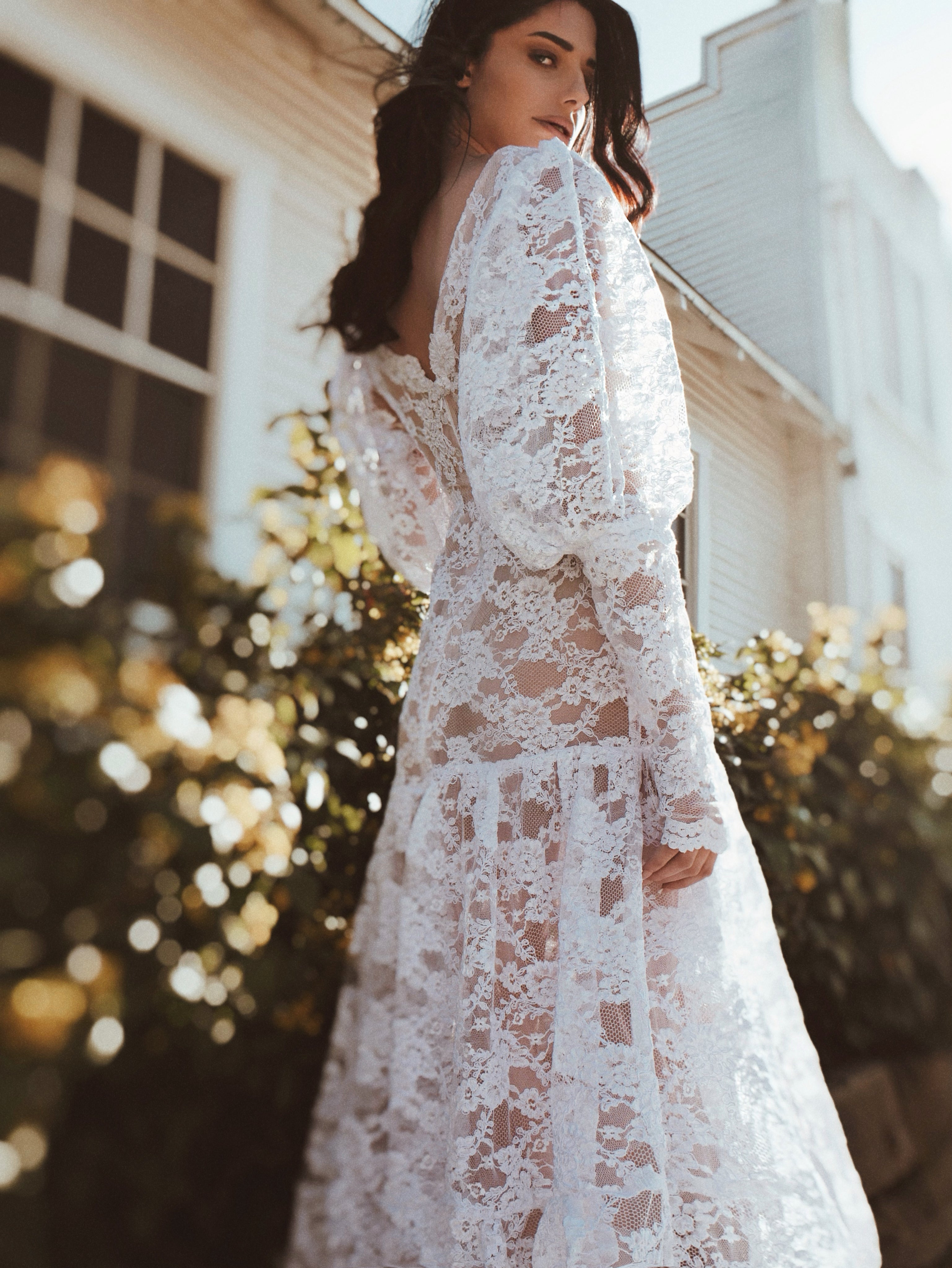 A model poses in a victorian style gigot sleeve wedding dress by Lauren Elaine Los Angeles.