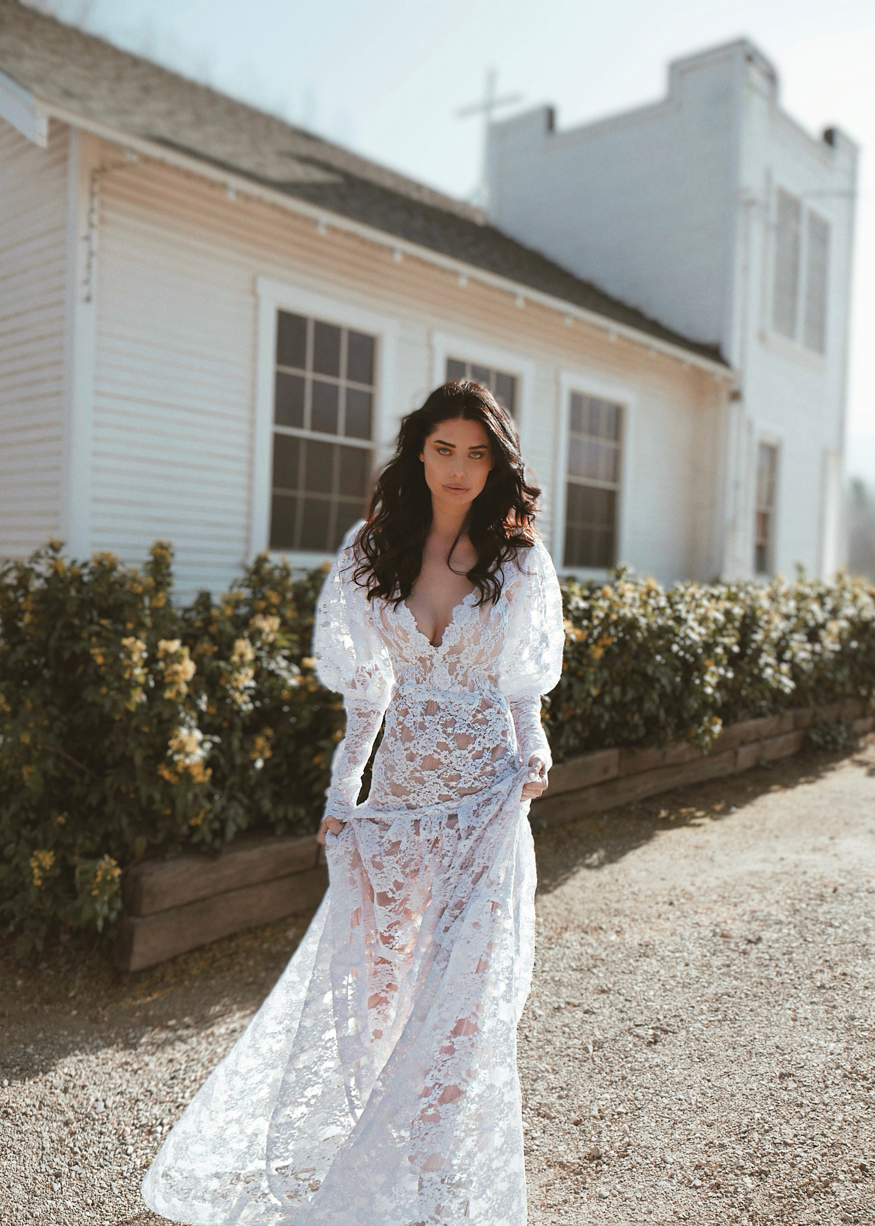 A model wears a vintage inspired long sleeve lace wedding gown.