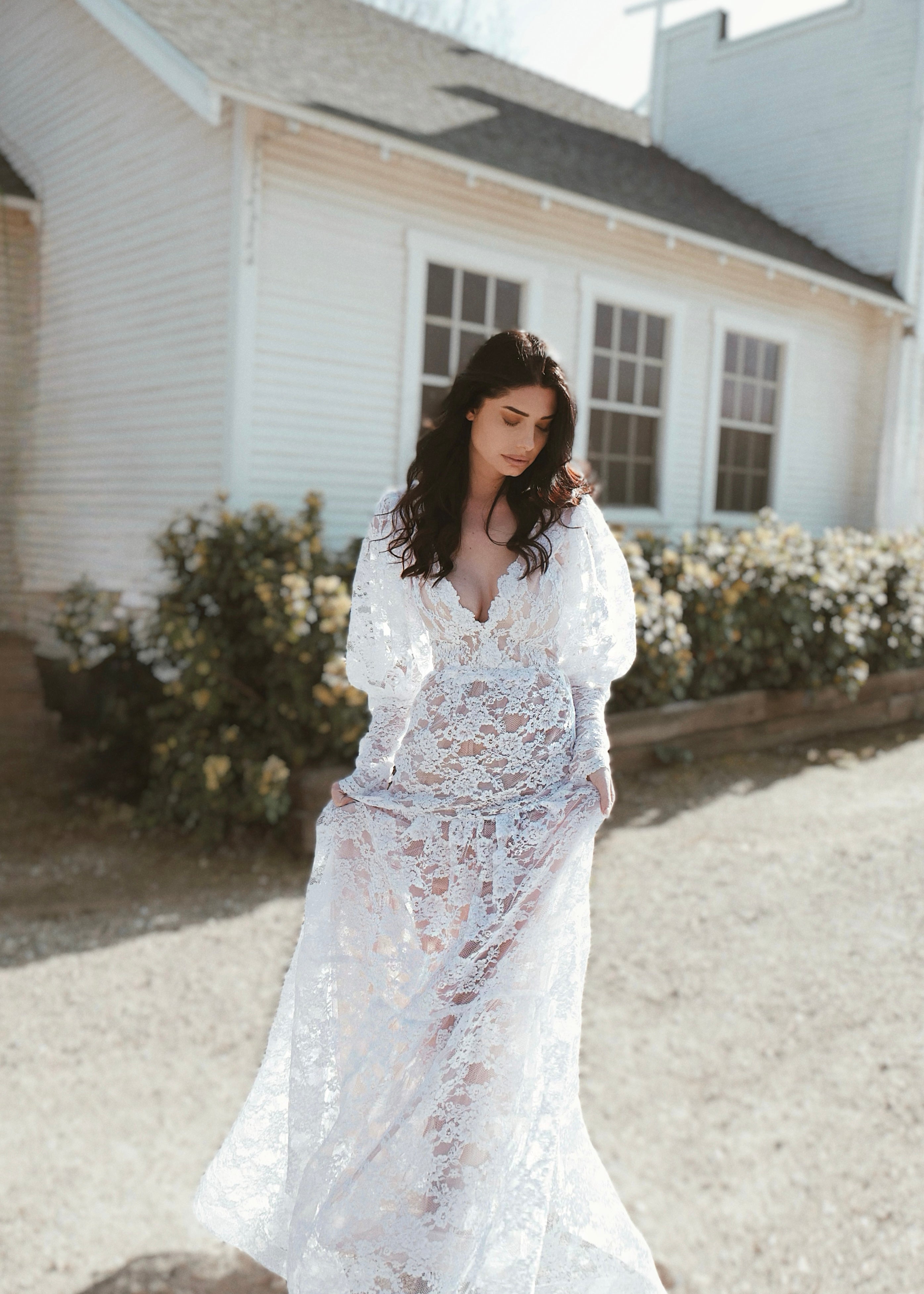 A model wears a bohemian long sleeve lace wedding dress by Lauren Elaine Los Angeles.
