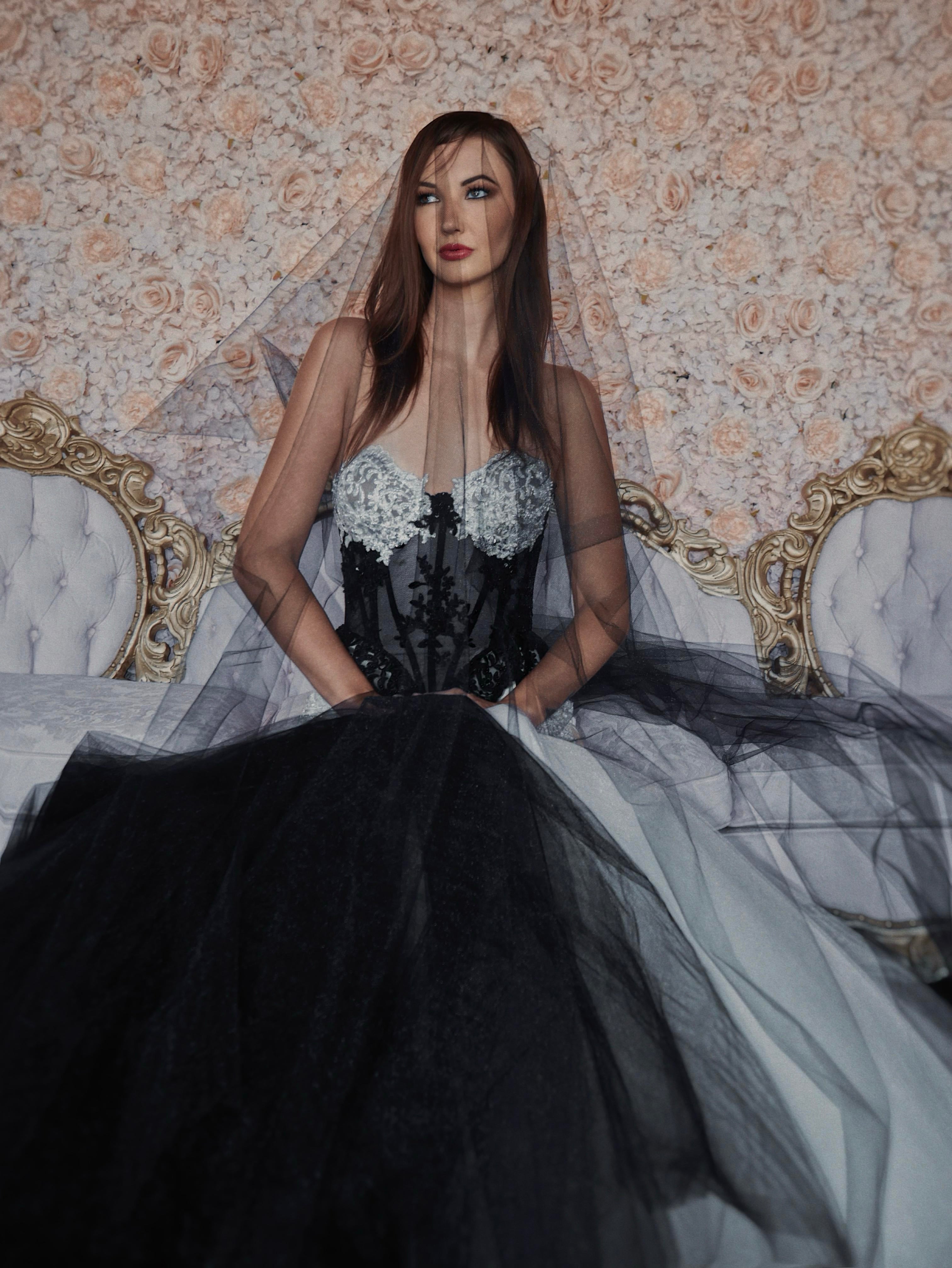 A model poses in a black wedding dress with corset bodice and black and white mermaid skirt.