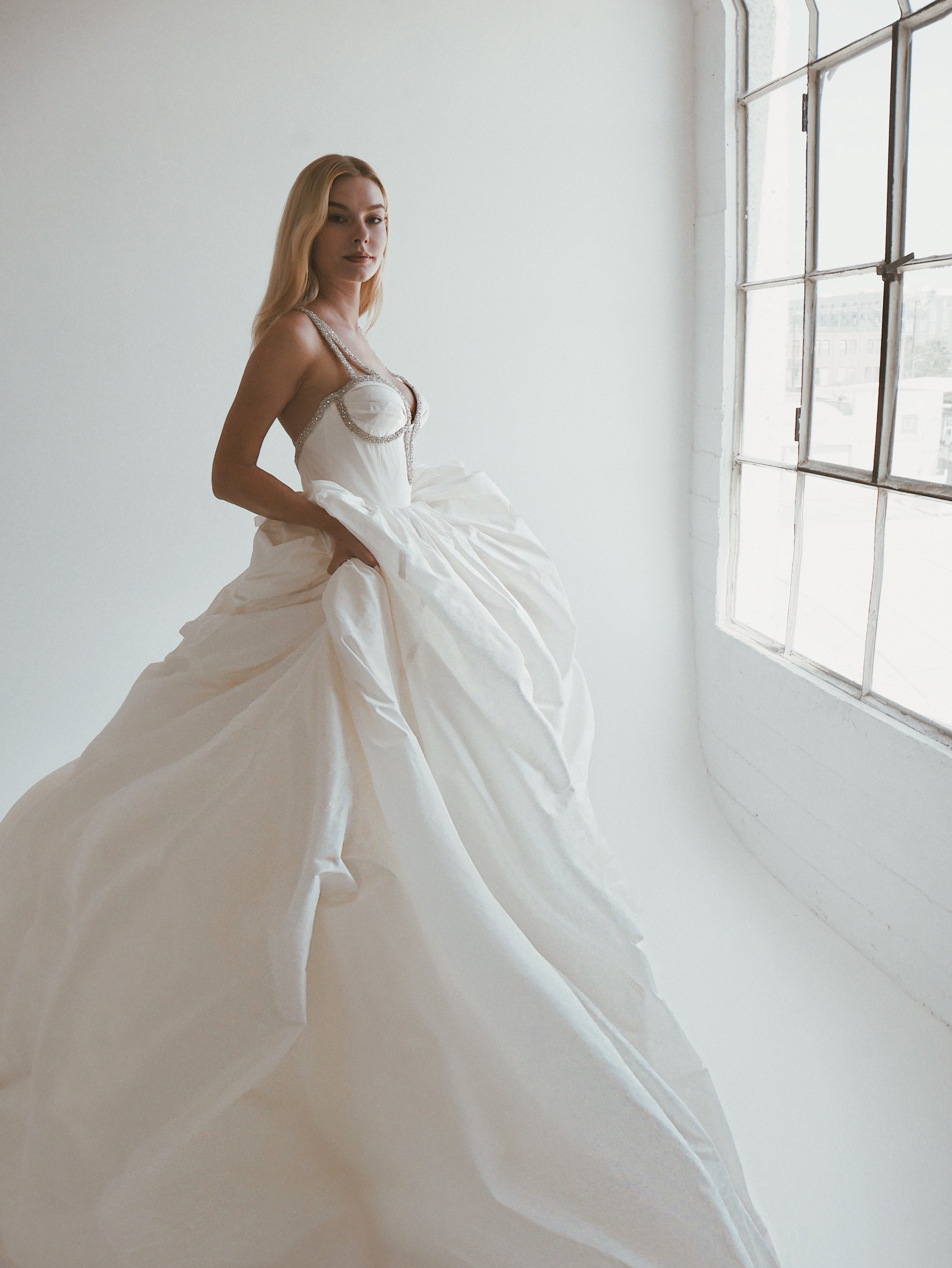 A model wears a clean and timeless silk taffeta corset ball gown wedding dress by Lauren Elaine