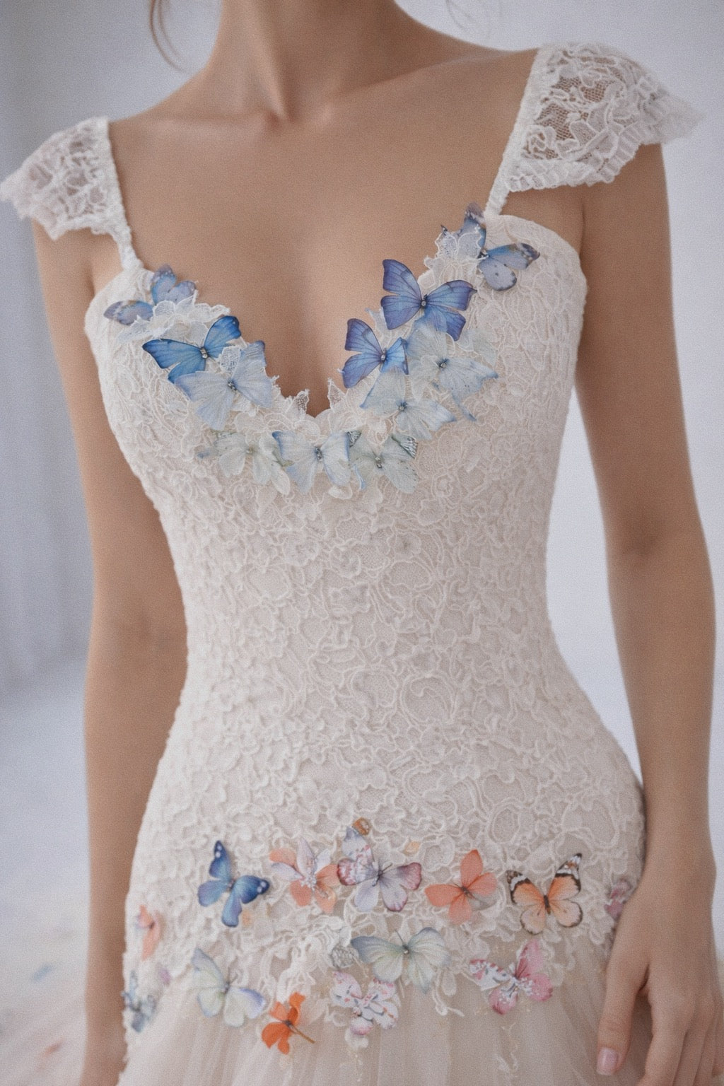 Butterfly embellished sweetheart neckline on a rainbow bridal gown with delicate lace detailing