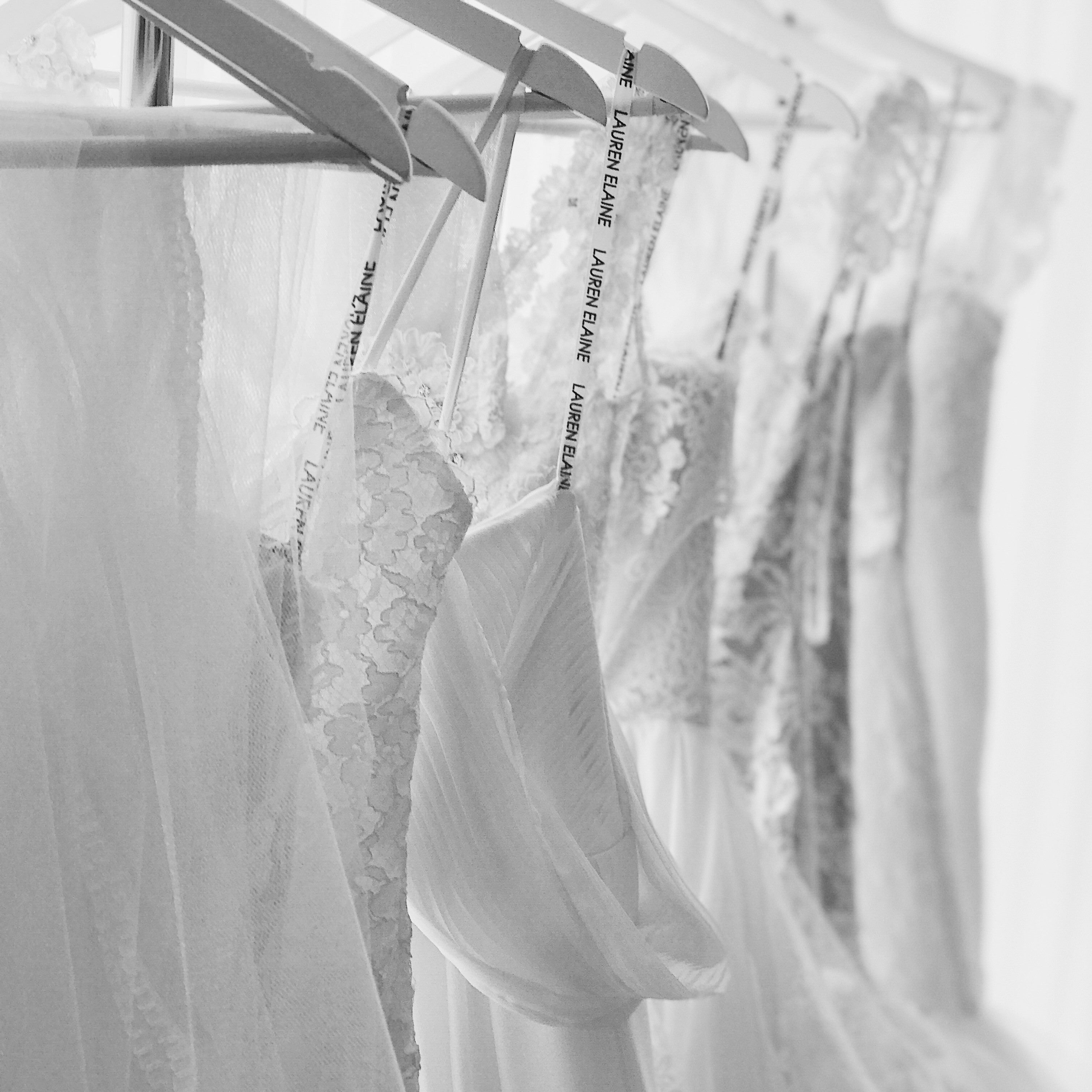 Wedding dresses hang on a rack inside the Lauren Elaine Los Angeles Bridal salon