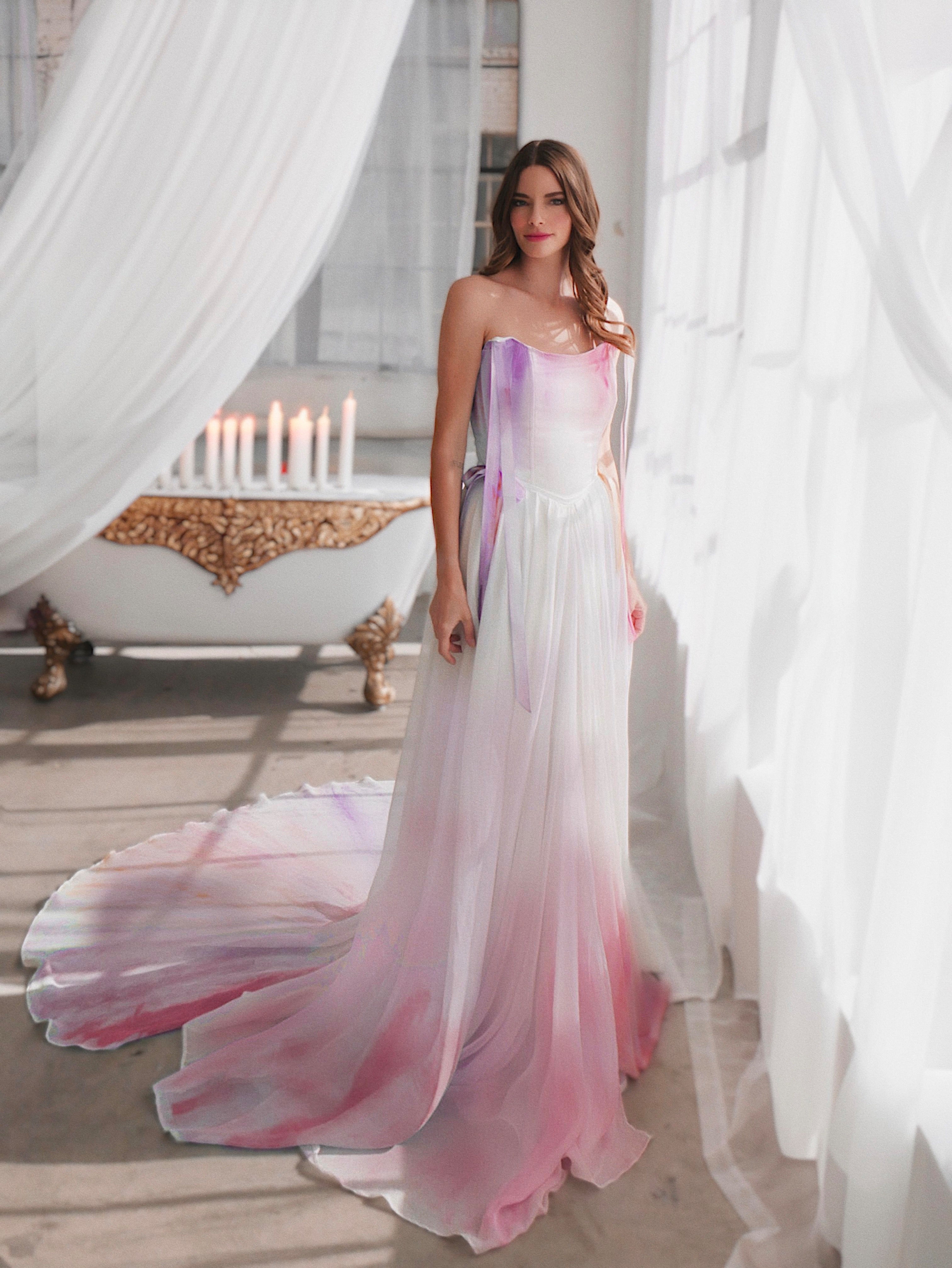 Rainbow watercolor ombré wedding dress styled indoors with flowing chiffon train and soft pastel hues