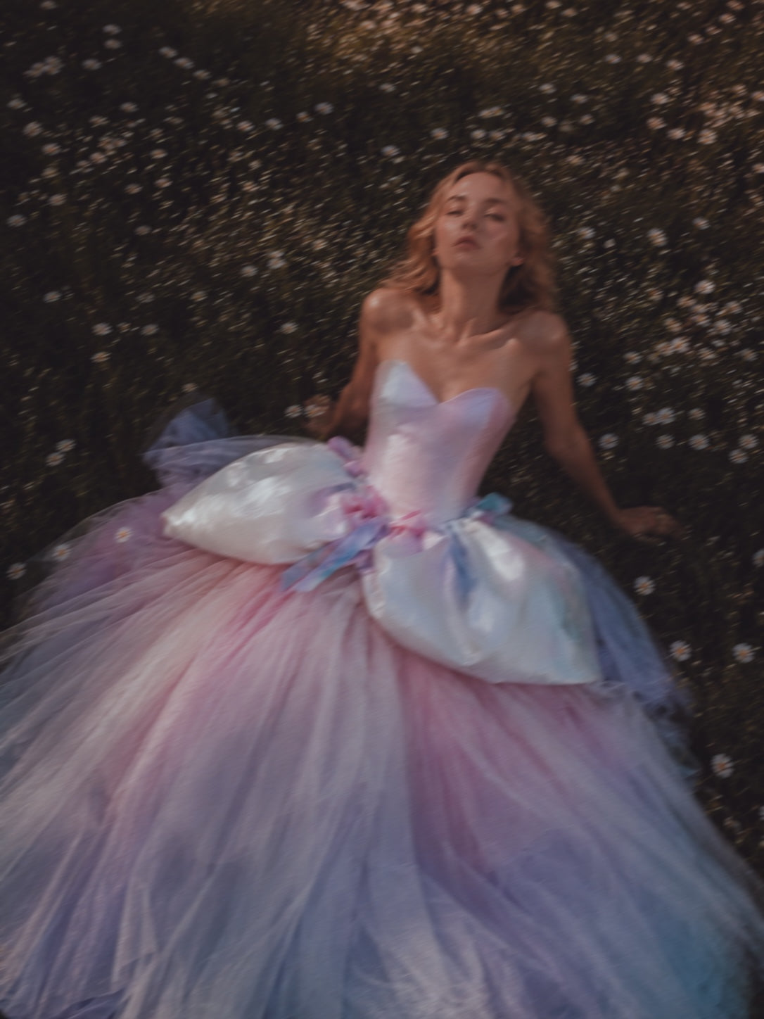 Editorial bridal portrait of the Moondreamer rainbow wedding dress with watercolor satin sweetheart bodice, balloon peplum waist detail, and layered pastel tulle skirt.