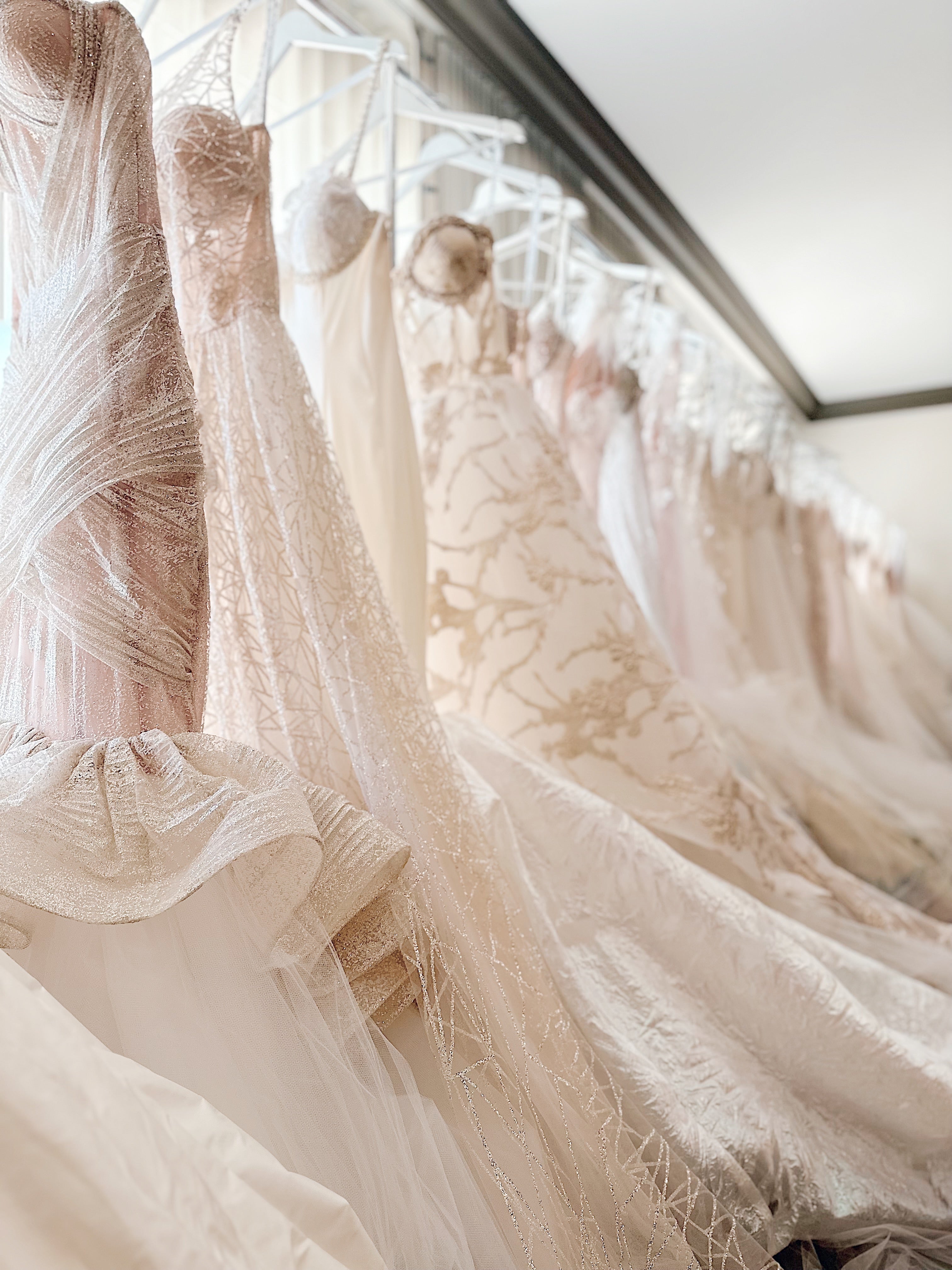Wedding dresses hangin on racks inside the Lauren Elaine Los Angeles Bridal Salon