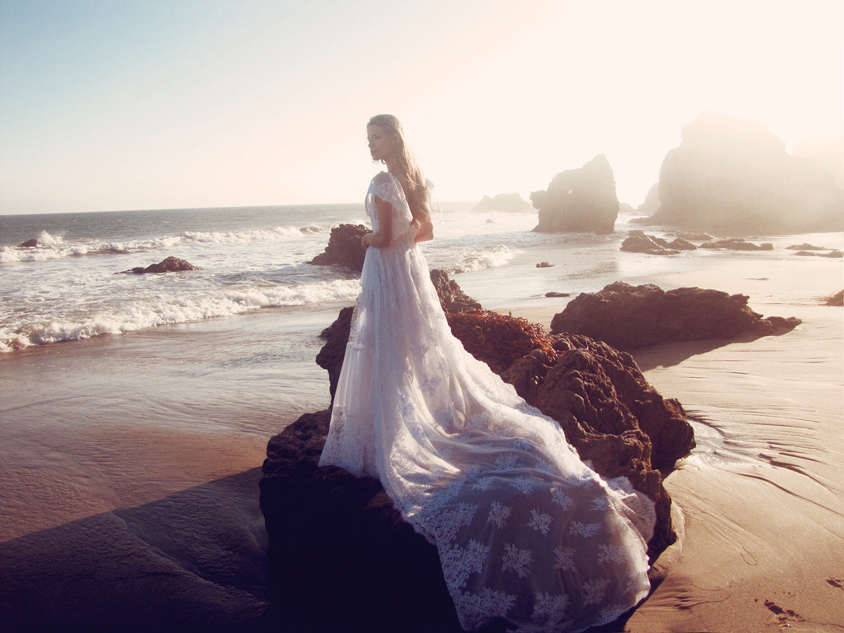 Astoria by Lauren Elaine Bridal features a detachable cathedral train and off-the-shoulder sleeves.