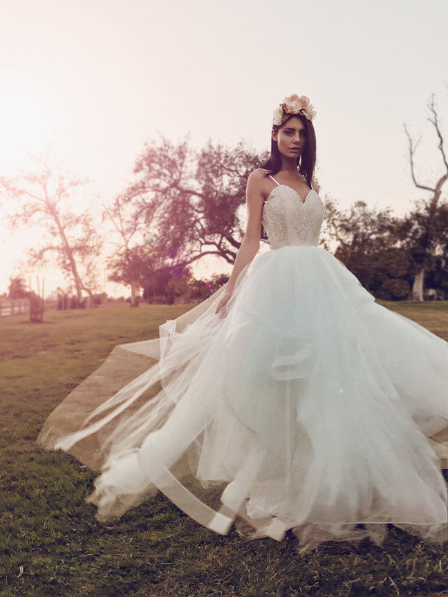 Fairytale blush tulle and lace ball gown wedding dress with horsehair hem twirling in the sunset.