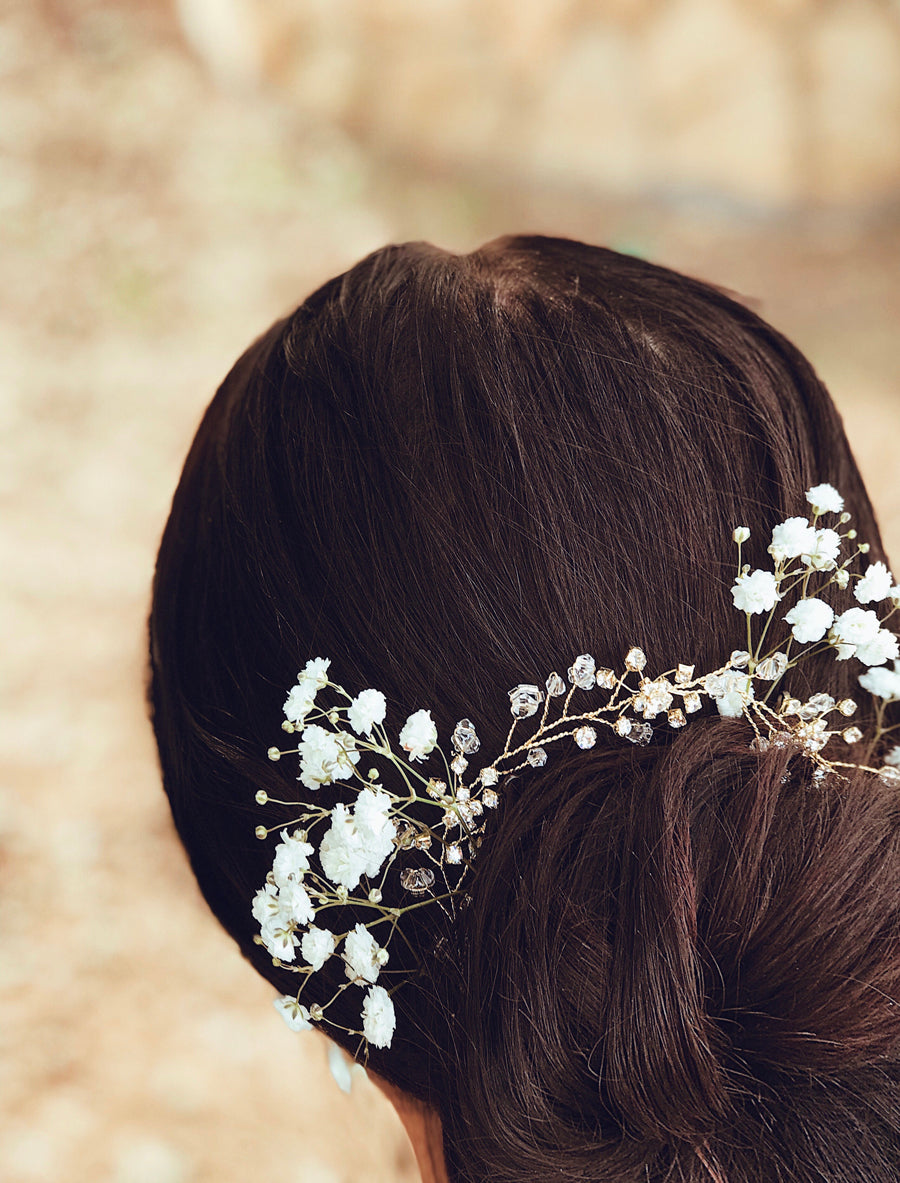 A bride wears the "Laurel" flower crown and hair vine from Lauren Elaine Bridal Accessories paired with baby's breath flowers