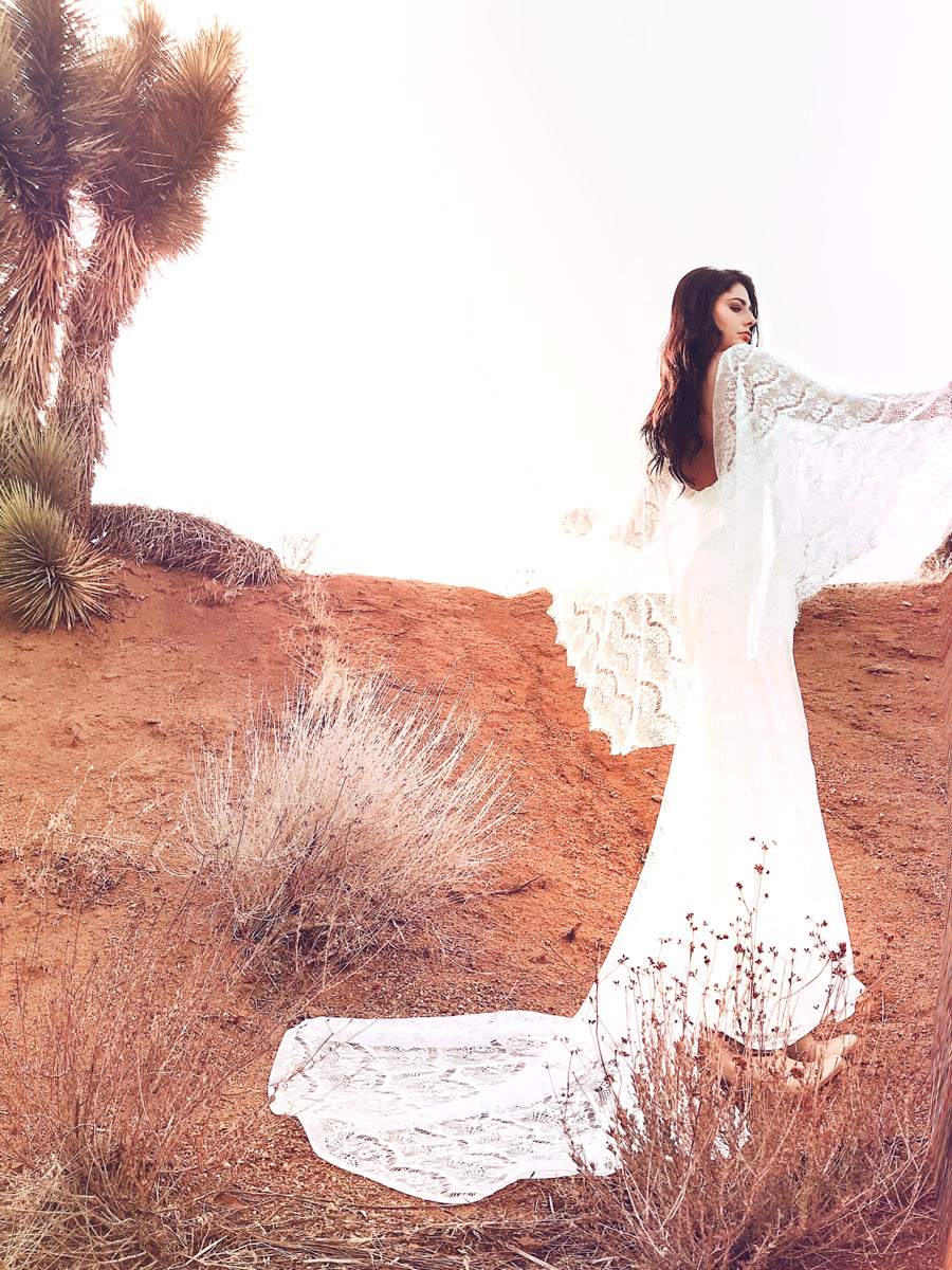 Bohemian lace sheath wedding gown with angel wing cape sleeves.
