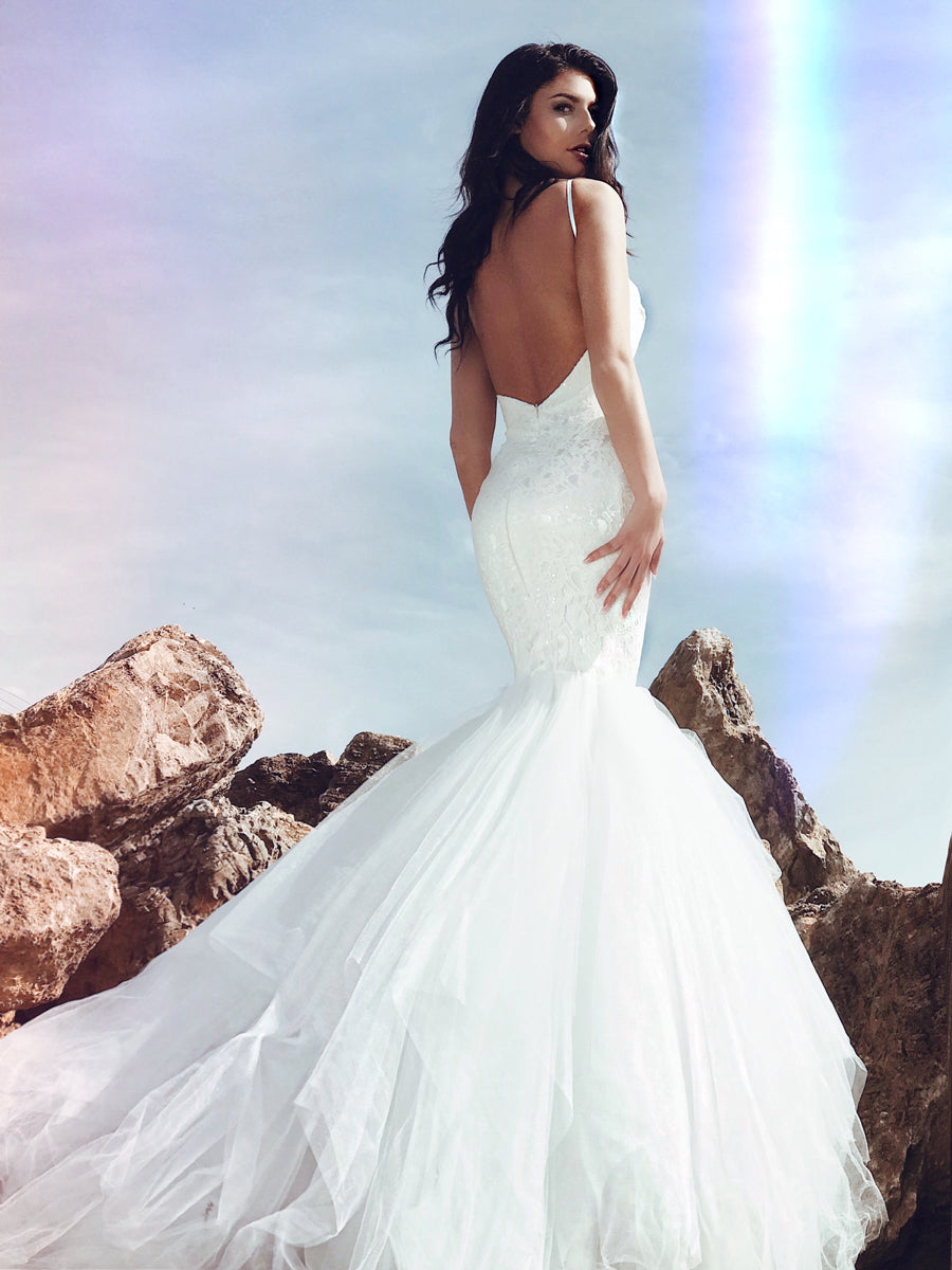 Backless mermaid wedding dress with tulle cathedral train and sparkle sequins on a lace sweetheart bodice.